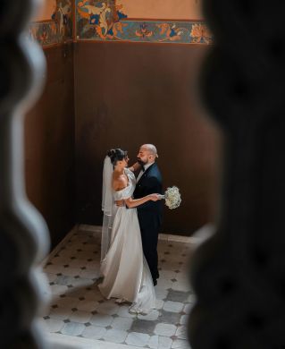 Bride and groom share a romantic dance in a beautifully decorated historic venue.