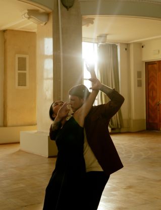 Graceful dance couple in an elegant pose, sunlit ballroom ambiance.